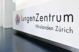 Der modern gestaltete weisse Empfangstresen mit dem Logo und Schriftzug des LungenZentrums Hirslanden Zürich