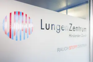 Der modern gestaltete weisse Empfangstresen mit dem Logo und Schriftzug des LungenZentrums Hirslanden Zürich