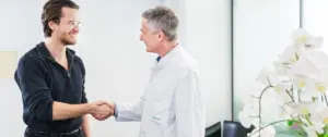Arzt schüttelt männlichen Patienten die Hand