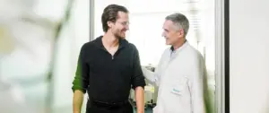 Arzt und Patientin unterhalten sich lächelnd während eines Beratungstermins im LungenZentrum Hirslanden Zürich