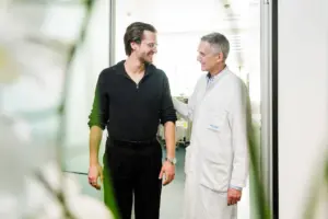 Arzt und Patientin unterhalten sich lächelnd während eines Beratungstermins im LungenZentrum Hirslanden Zürich